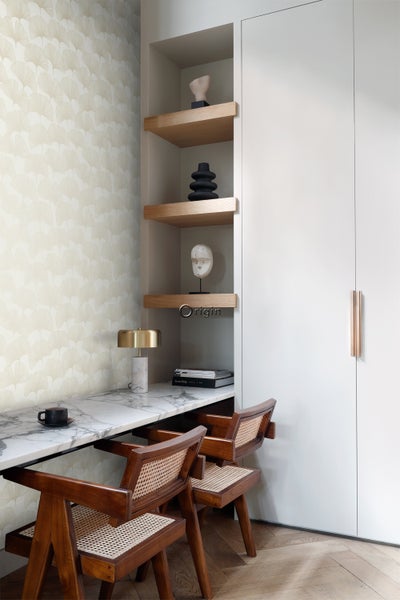 Elegantes Arbeitszimmer mit Marmorplatte, Holzstühlen und Wandregalen