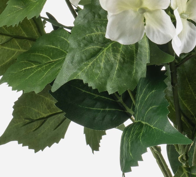 Nahaufnahme einer Kunstpflanze mit grünen Stoffblättern und weißen Blüten.