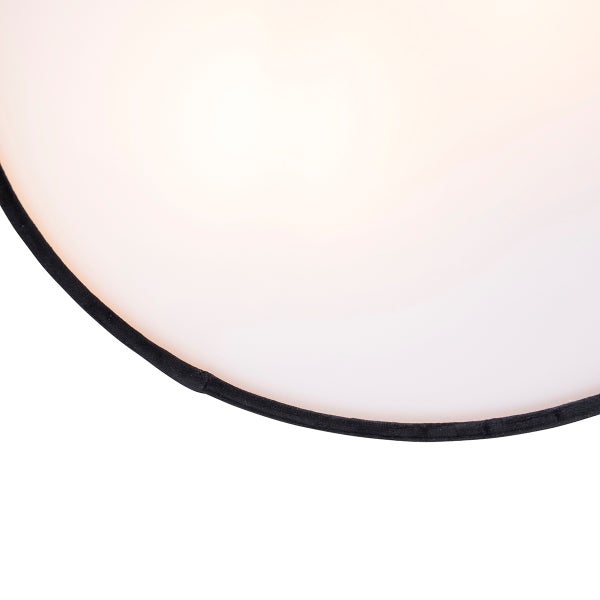 Detailaufnahme einer runden Deckenleuchte mit weißem Kunststoffschirm und schwarzer Textilkante.