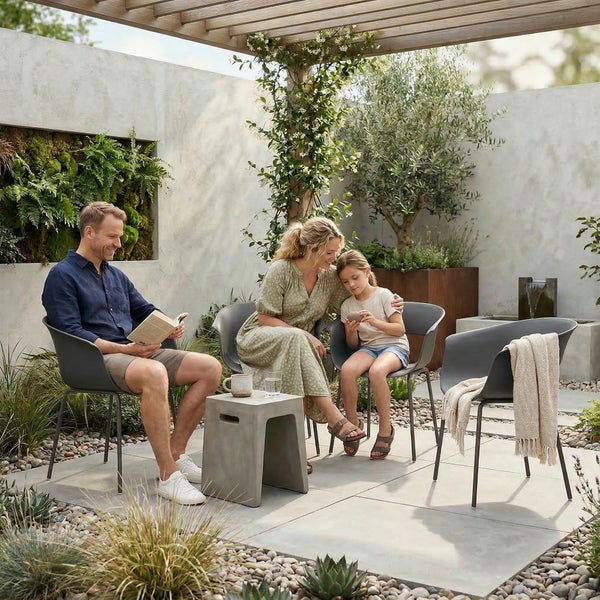 Familie entspannt auf moderner Gartenterrasse mit Steingarten, Pflanzkübeln, Wasserbecken und hochwertigen Gartenmöbeln aus Kunststoff.