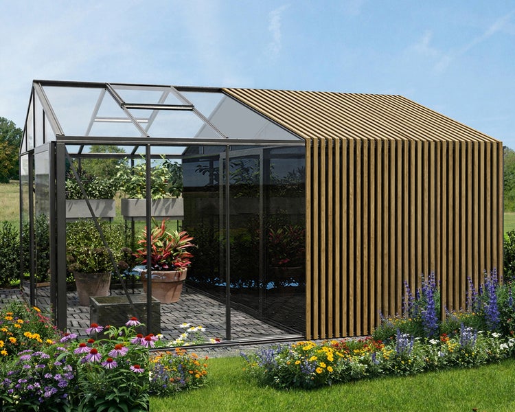 Modernes Gewächshaus mit Glaswänden und einem Bereich aus vertikalen Holzlatten, umgeben von einem Blumengarten.