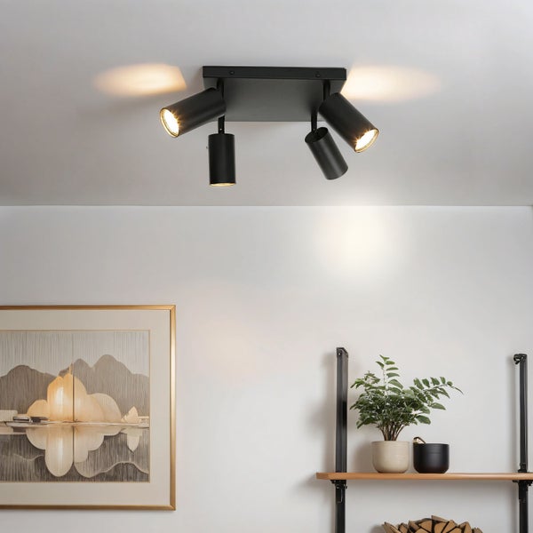 Moderne vierflammige Deckenleuchte in zylindrischer Form an der Zimmerdecke montiert mit warmweißem Lichtschein in einem modern eingerichteten Raum.