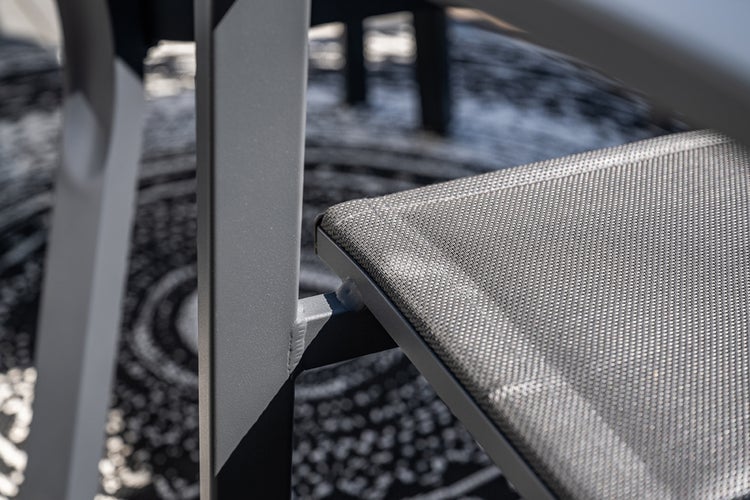Detailansicht eines Gartenstuhls mit Metallrahmen und wetterfester Textilbespannung der Sitzfläche.