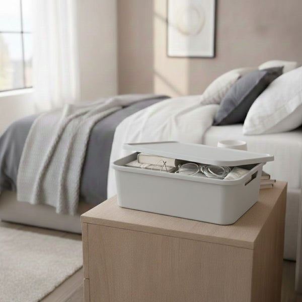 Aufnahme eines Schlafzimmers mit einer Aufbewahrungsbox mit Deckel auf einem Nachttisch.