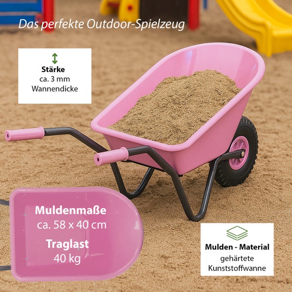Rosa Kinderschubkarre mit Sand auf einem Sandplatz