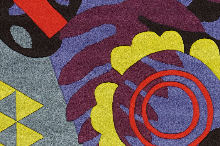 Detailansicht eines modernen Webteppichs mit abstrakten geometrischen Formen und floralen Mustern in einer strukturierten Oberfläche.