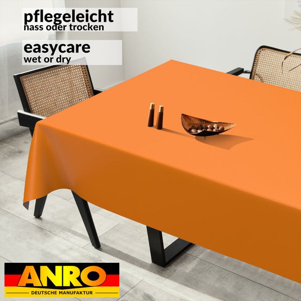 Orangefarbene Tischdecke auf einem Esstisch, pflegeleicht nass oder trocken, ANRO Deutsche Manufaktur Logo.