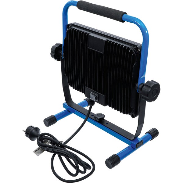 Mobiler LED-Baustrahler in Blau und Schwarz mit verstellbarem Gestell, gepolstertem Griff und Netzkabel, Rückansicht.