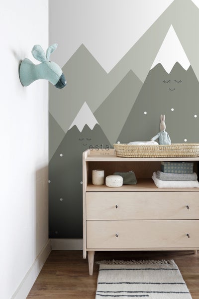 Kinderzimmer mit Bergmotiv-Tapete, Kommode und Stofftier-Dekoration