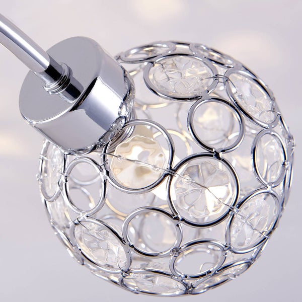 Nahaufnahme einer runden Deckenleuchte mit verchromtem Gestell und klaren Kristalleinsätzen.