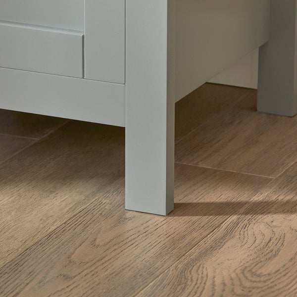 Detailansicht eines Unterschranks mit Fuß auf Holzboden