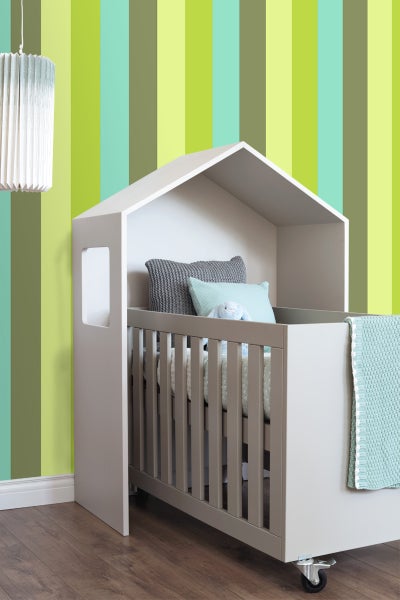 Kinderbett im Hausdesign mit Rollen und Textilien