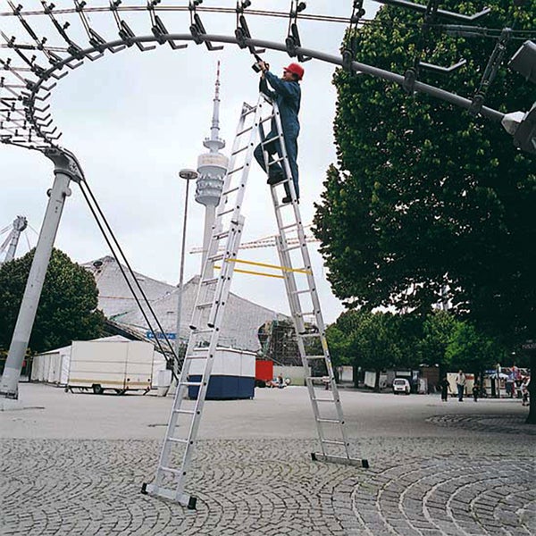 Eine Person arbeitet auf einer Aluminium-Mehrzweckleiter im Freien.