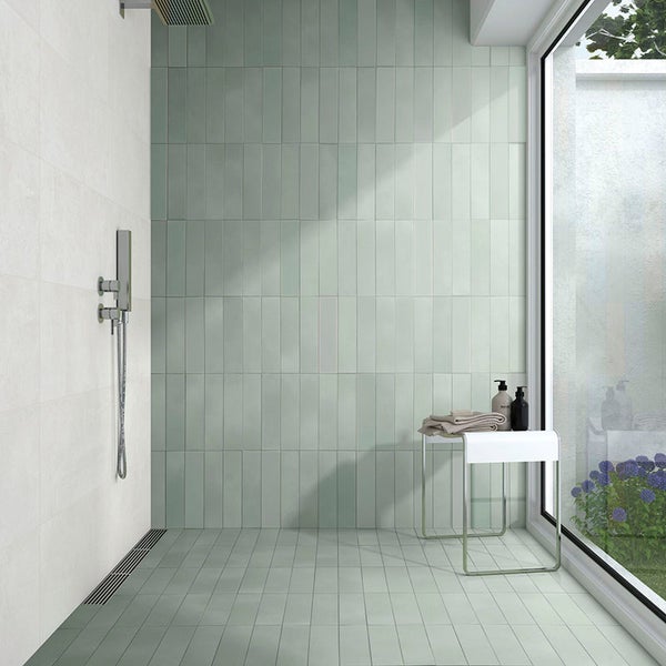 Modernes Badezimmer mit rechteckigen Wand- und Bodenfliesen, Duscharmatur und bodengleicher Dusche mit großem Fenster.
