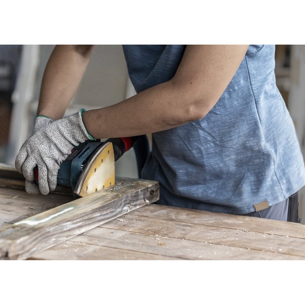 Eine Person schleift mit einem Schleifgerät ein Holzbrett.