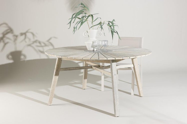 Runder Gartentisch aus Holz mit sternförmig angeordneten Lamellen und ein passender Gartenstuhl in heller Holzoptik.