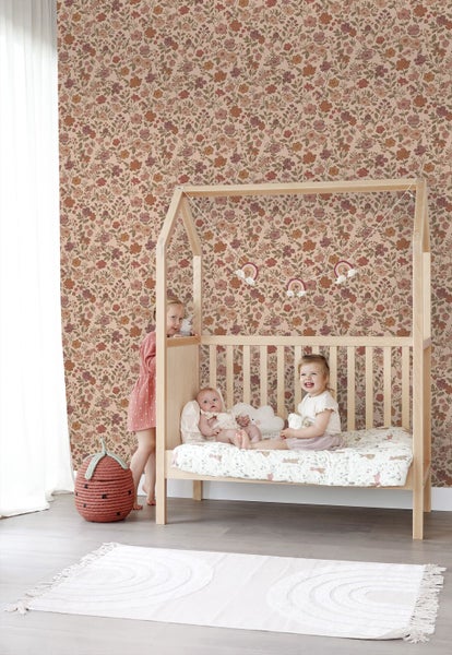 Florale Vliestapete mit kleinen Blumen in einem hellen Kinderzimmer mit Kindern und einem Hausbett aus Holz.