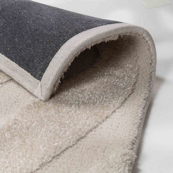 Nahaufnahme eines Hochflor Teppichs mit weichem Flor, gewebter Rückseite und geketteltem Rand.