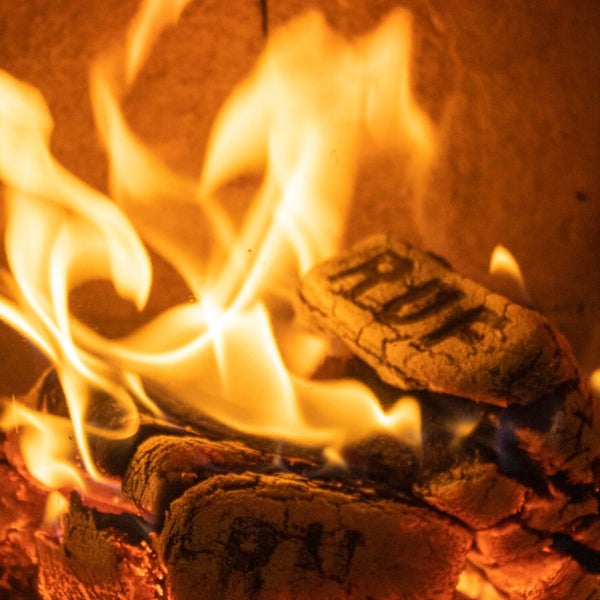 Brennende RUF Holzbriketts mit hellen Flammen in einem Kamin.