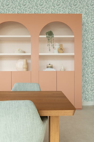 Helles Zimmer mit Esstisch, Stühlen und Bücherregal