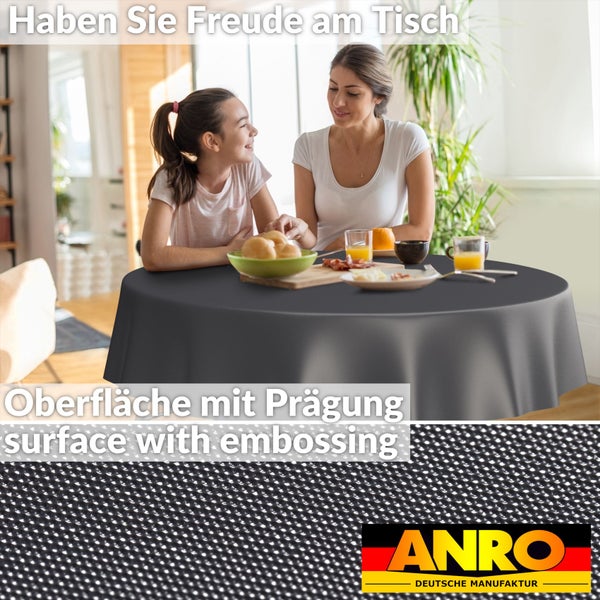 Rundes, anthrazitfarbenes Tischtuch mit geprägter Oberfläche in einer hellen Esszimmerszene mit Mutter und Kind, Detailansicht und ANRO Logo.