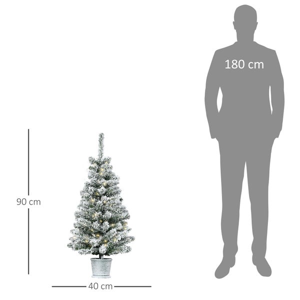 Künstlicher Weihnachtsbaum im Topf, beschneit mit LED Beleuchtung, Höhe 90 Zentimeter, Breite 40 Zentimeter, Größenvergleich mit einer Person.