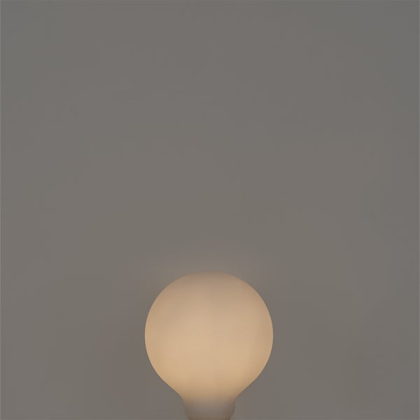 Matte, runde Glühbirne, die warm leuchtet.