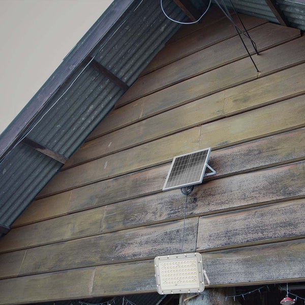 Solarpanel mit LED-Strahler an einer Holzwand