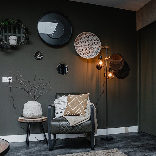 Wohnzimmer mit Sessel, Stehlampe und Wanddekorationen