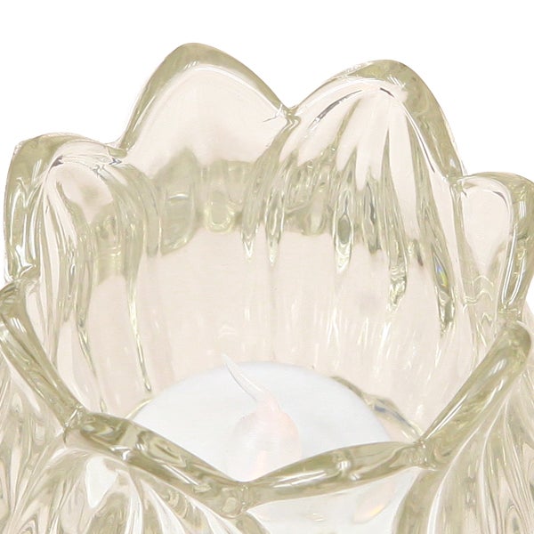 Teelichthalter aus klarem Glas in Blumenform mit einem weißen Teelicht im Inneren.