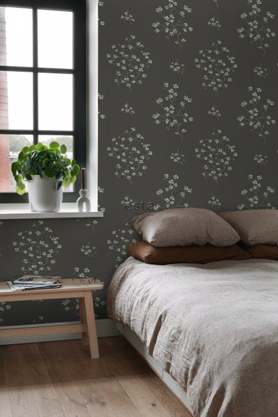 Schlafzimmer mit Bett, Beistelltisch und gemusterter Tapete