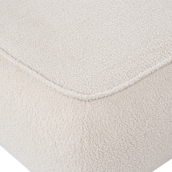 Detailaufnahme eines Polstermöbels mit strukturiertem Bouclé-Stoff und einer Naht.