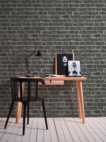 Szene mit Schreibtisch, Stuhl, Lampe und Wandtapete in Steinoptik