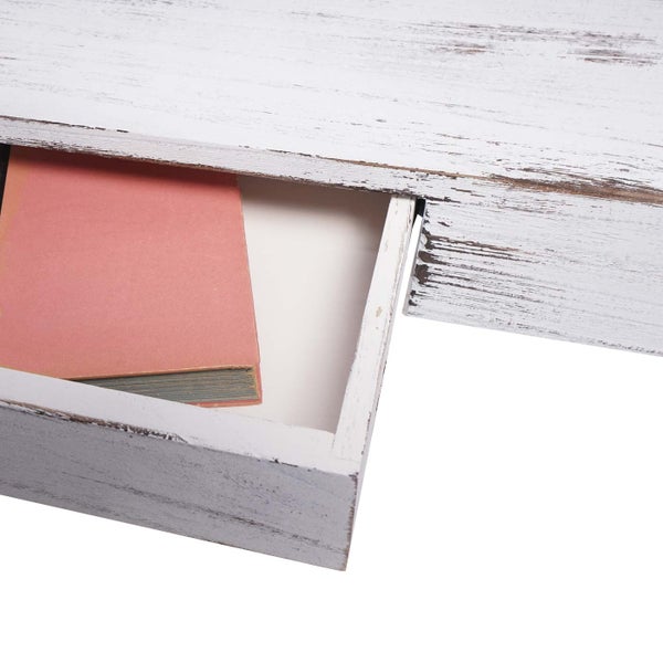 Detailaufnahme einer weißen Holzkommode mit geöffneter Schublade und Buch