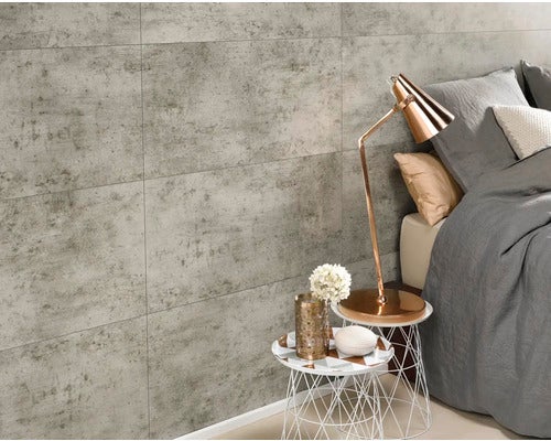 Heller Raum mit Wandfliesen in Betonoptik, Nachttisch und Bett