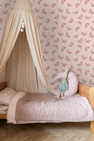 Kinderzimmer mit Bett, Baldachin und Schmetterlingstapete