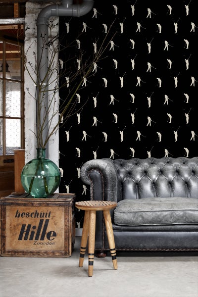 Wohnzimmer mit Tapete mit Golfmotiv, Ledersofa und Holzhocker