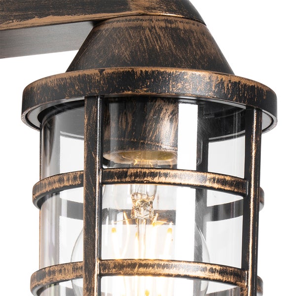 Außenwandleuchte im Industriedesign mit Metallkäfig, Glaszylinder und leuchtendem Filament-Leuchtmittel.