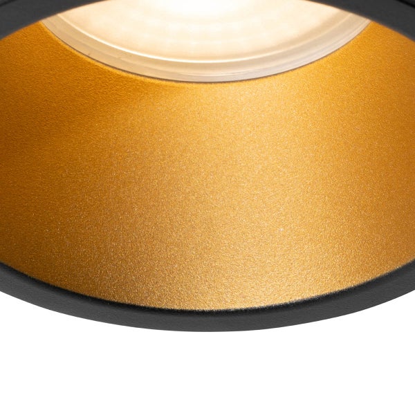 Nahaufnahme eines Deckenstrahlers mit goldfarbenem strukturiertem Reflektor und schwarzem Außenring.