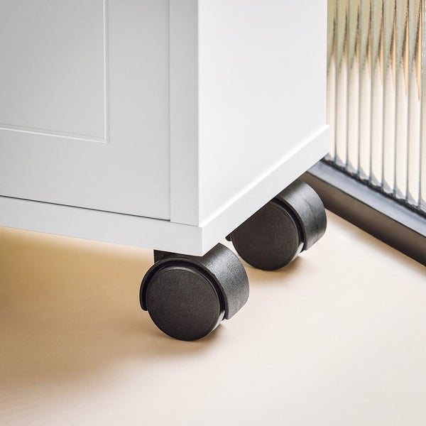 Detailaufnahme eines weißen Möbels mit Rollen