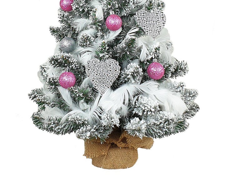 Künstlicher Weihnachtsbaum mit Kunstschnee, geschmückt mit Christbaumkugeln und Dekorationen, in einem Jutesack stehend.