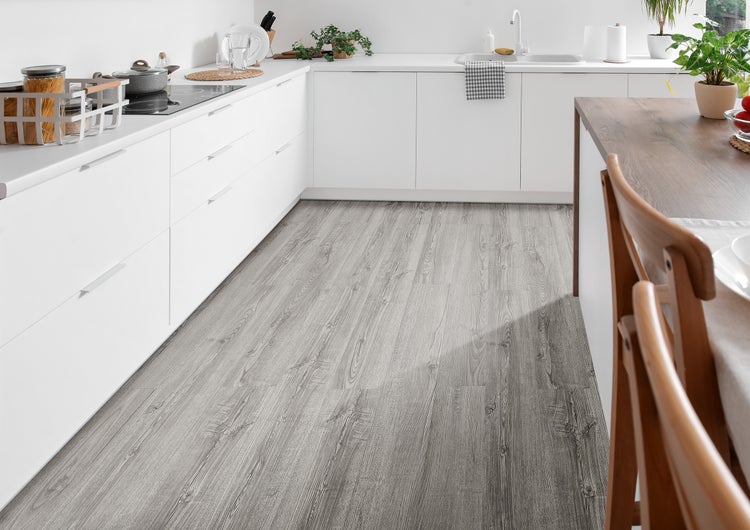 Moderne helle Küche mit weißen Schränken und einem grauen Vinylboden in Holzoptik.