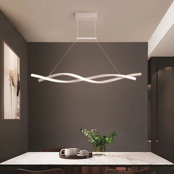 Moderne Pendelleuchte mit wellenförmigem Design über einem Esstisch.