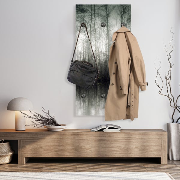 Szene mit Garderobenpaneel mit Waldmotiv, Mantel und Tasche an der Wand über einer Kommode