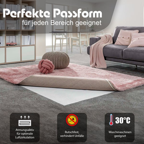 Wohnzimmer mit rosa Teppich, Sofa, Regalen und Dekorationen; der Teppich ist atmungsaktiv, rutschfest und waschmaschinengeeignet bis 30 Grad