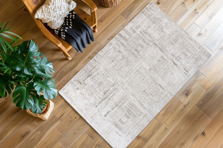 Wohnzimmer mit Teppich mit geometrischem Muster auf Parkettboden neben einem Sessel mit Decke und einer Monstera Zimmerpflanze.