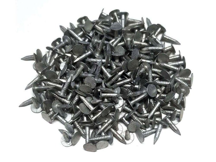 Haufen großköpfige Stahlnägel mit geripptem Schaft für Dachpappen oder Teppichbefestigung.
