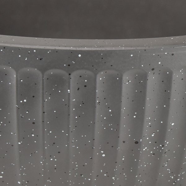 Detailansicht eines Pflanzgefäßes mit vertikaler Rillenstruktur und gesprenkelter Oberfläche in Gesteinsoptik.