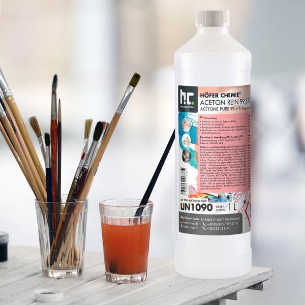 Flasche mit Acetonreiniger 99,5 % von Höfer Chemie neben Pinseln und einem Glas mit Reinigungsflüssigkeit.