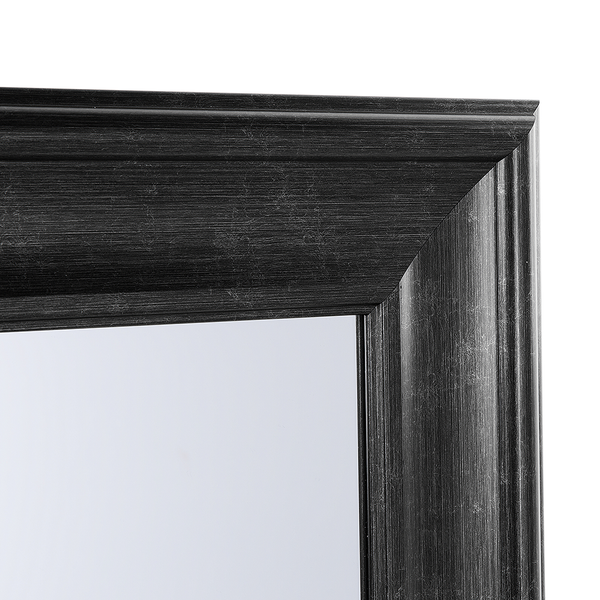 Detailansicht der Ecke eines Wandspiegels mit profiliertem Rahmen in Holzoptik